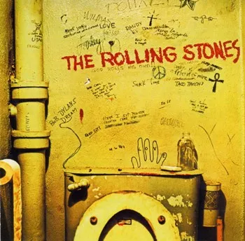 A graffiti-covered bathroom wall above a toilet, from the cover of the Rolling Stones album Beggars Banquet